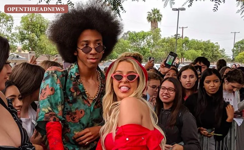 Fans with blank lanyard badges packed into long lines outside a hotel ballroom, recreating the overcrowded chaos of TanaCon, Tana Mongeau's disastrous 2018 fan convention.