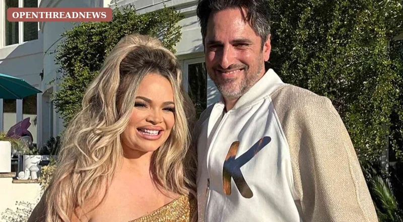 A blonde woman and her dark-haired husband laughing together on a couch at home, for the section on Trisha Paytas and Moses Hacmon
