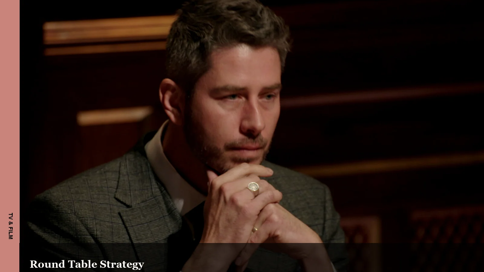 Arie Luyendyk Jr. seated at a Traitors round table in a tense game moment